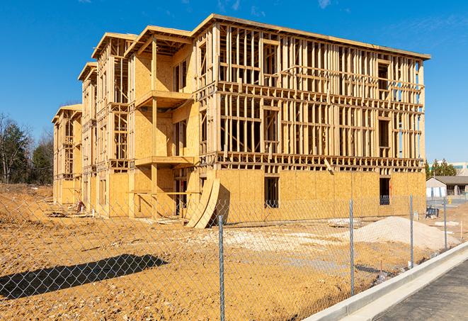 a job site enclosed by temporary chain link fences, ensuring safety for workers and pedestrians in Manorville NY